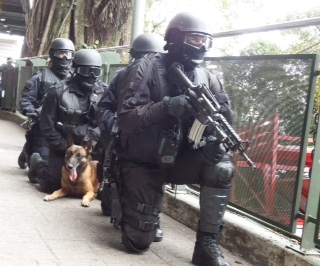 Aguardando os possíveis resultados de uma negociação em andamento com o “terrorista”, equipe mista do BOPE/BAC prepara-se para entrar em ação direta. (Imagem: Ronaldo Olive)