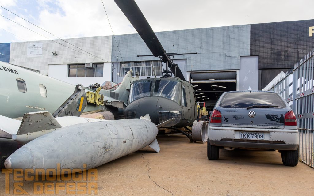 Logo na entrada, o VW Gol e um UH-1 "Hzão" formam o caminho até o prédio. Foto: Gabriel Centeno.