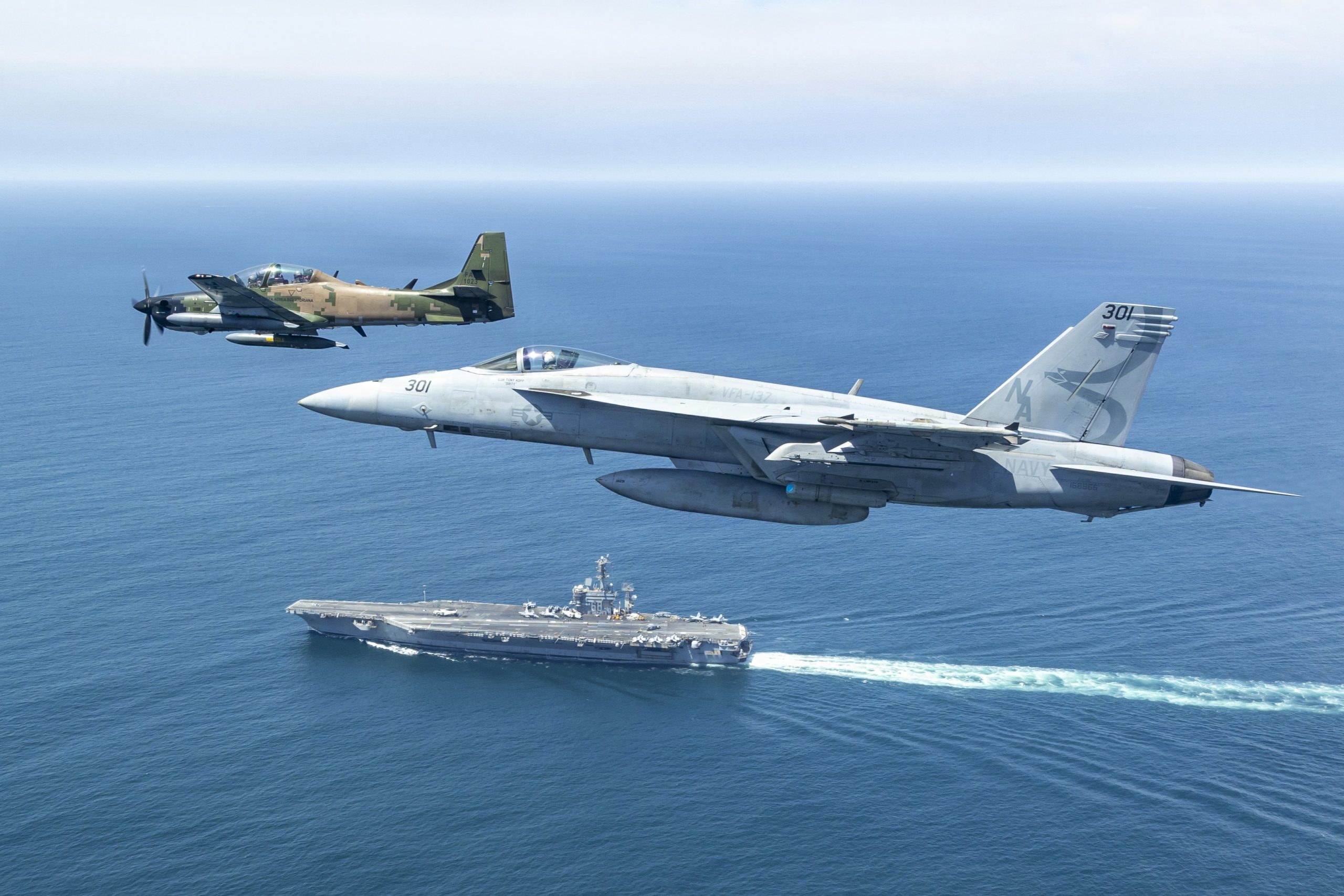 A-29 Super Tucano do Equador e F/A-18E Super Hornet da Marinha dos EUA sobrevoam o USS Nimtz durante a Southern Seas 2026. (Foto: tenente William “Simple Will” Shortal/Marinha dos EUA/Divulgação)