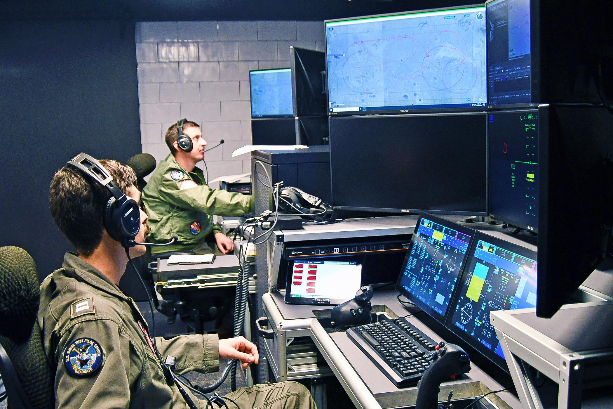 Pilotos de MQ_25 na estação de comando e controle MD-5C (Marinha dos EUA/Divulgação)
